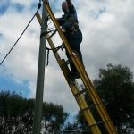 Safety harness for overhead power pole